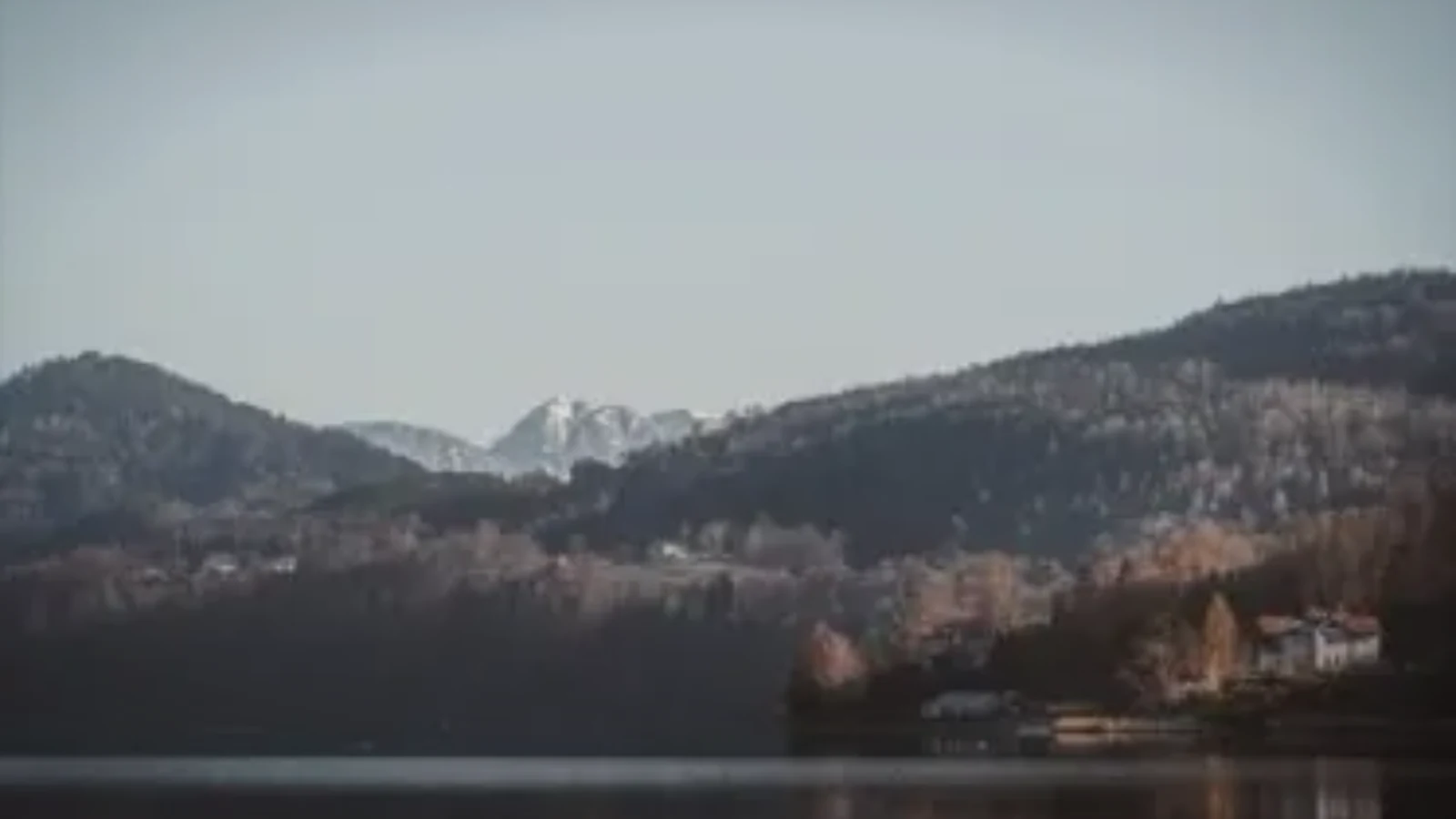 A still lake at dawn under soft light.